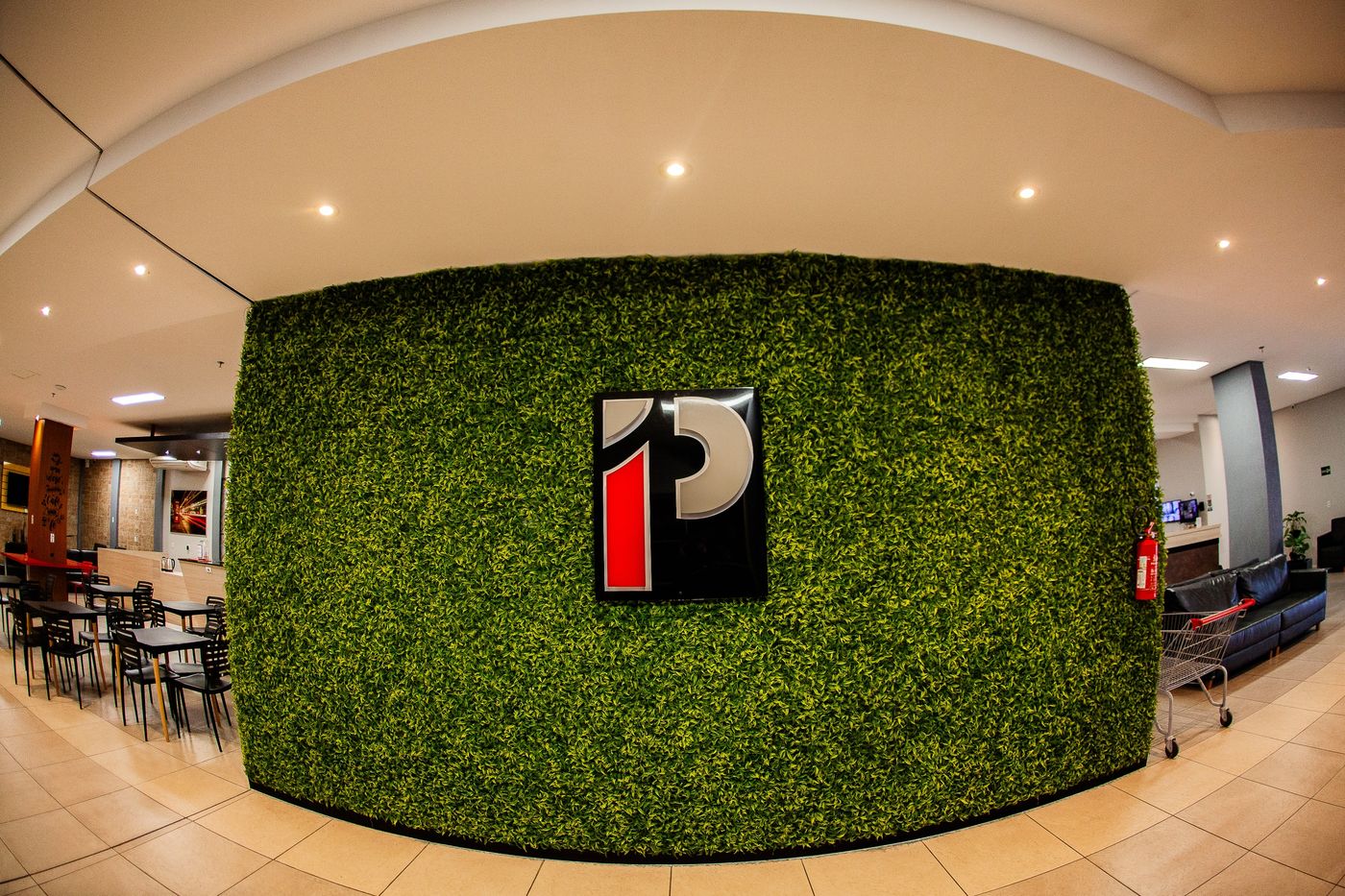 Recepção do Prime Hotel com parede verde e logotipo